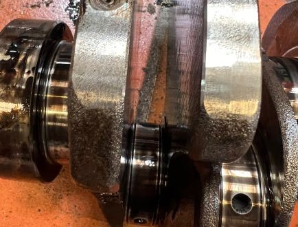 Close-up of crankshaft journals showing engine wear during inspection