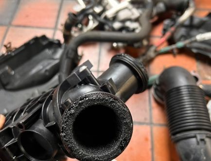 Engine pipe and component assembly being inspected during repair